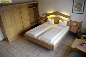 a bed room with two beds and a desk at Hotel Pappelhof in Weidenbach