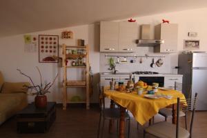 una cocina con una mesa con un mantel amarillo. en La Sirena, en Augusta