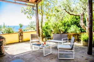 een patio met 3 stoelen en een tafel en een tafel bij Casa Il Negrito in Massa Lubrense