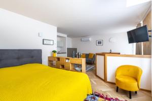 a bedroom with a yellow bed and a yellow chair at Les Suites de Saint Amand in Bordeaux