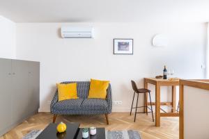 a living room with a chair and a table at Les Suites de Saint Amand in Bordeaux