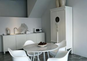 uma sala de jantar com uma mesa e cadeiras brancas em Studio L em Lovina