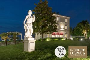 posąg w trawie przed domem w obiekcie Relais Villa Belvedere & SPA ONLY ADULTS w mieście Pozzolengo +37 zdjęć