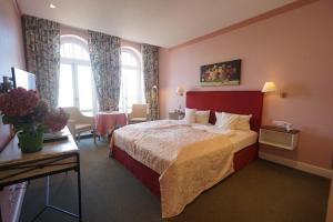 a hotel room with a large bed and a desk at Aparthotel Am Meer in Cuxhaven