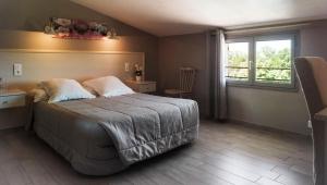 een slaapkamer met een groot bed en een raam bij Hôtel Casa di Mama in Porto-Vecchio