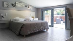 a bedroom with a bed and a sliding glass door at H&ocirc;tel Casa di Mama in Porto-Vecchio