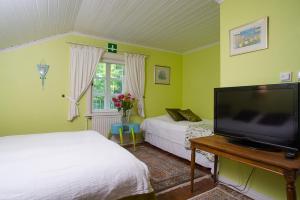 a bedroom with two beds and a flat screen tv at Koivulan Kartano in Lohja