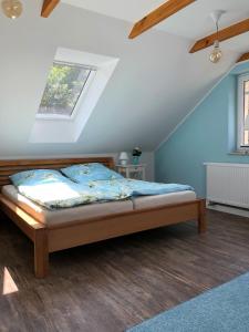 Schlafzimmer mit einem Bett mit blauen Wänden und einem Fenster in der Unterkunft Adlerhorst in Königstein an der Elbe