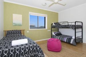 a bedroom with two bunk beds and a window at Lennox on the Beach Unit 2 - Lennox Head in Lennox Head
