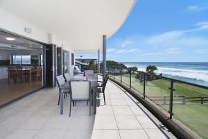 a balcony with a table and chairs and the ocean at Lennox on the Beach Unit 2 - Lennox Head in Lennox Head