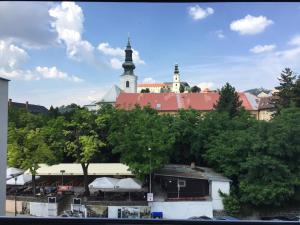 Blick auf eine Stadt mit einer Kirche im Hintergrund in der Unterkunft Hotel Alexander's in Nitra