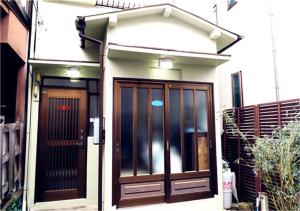 a house with a brown door and a fence at Kiki HouseT --Self Check-in -- Room Number & Password is in the following email in Tokyo