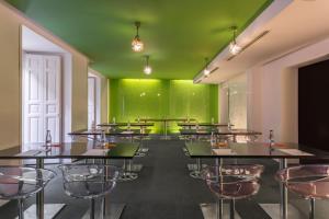 a room with tables and chairs and a green wall at Room Mate Mario in Madrid