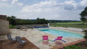 a swimming pool with chairs and a table and a picnic table at Le Champêtre in Bazoges-en-Pareds
