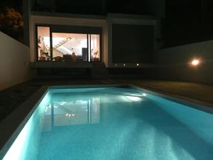 a swimming pool at night with a reflection in a mirror at VillaMar in Sesimbra