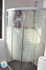 a shower with a glass enclosure in a bathroom at Antos Deluxe Apartment in Constanţa