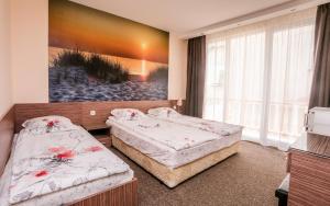 zwei Betten in einem Zimmer mit einem Gemälde an der Wand in der Unterkunft Stella Del Mare Guest House in Kiten + 27 Fotos