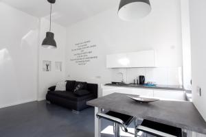 cocina y sala de estar con mesa y sofá en Mini Loft Design, en Budapest