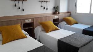 Postel nebo postele na pokoji v ubytování Hostal Cervantes Playa