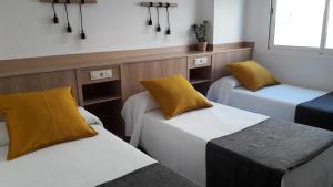 Кровать или кровати в номере Hostal Cervantes Playa