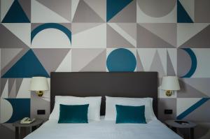 a bedroom with a bed with blue and white walls at Hotel Beatrice in Este