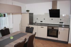 a kitchen with a table and a tv on the wall at Ferienwohnung Hengl in Ettenheim