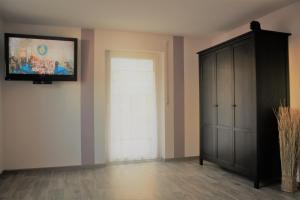 Zimmer mit einer Tür und einem TV an der Wand in der Unterkunft Ferienwohnung Hengl in Ettenheim