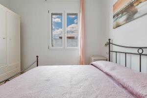 Habitación blanca con cama y ventana en Residence Pianeta Mare, en Torre Lapillo