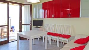 ein Wohnzimmer mit einem weißen Tisch und roten Schränken in der Unterkunft La Quiete 23 Lake view apartment by Gardadomusmea in Tremosine sul Garda