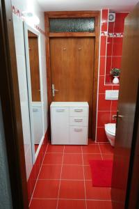 een rode badkamer met een toilet en een rode tegelvloer bij Apartman Marica in Opatija