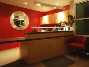 a bar with a mirror and a red wall at Park View Motor Lodge in Hamilton