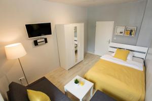 a small bedroom with a yellow bed and a tv at Ferienwohnung Raabstraße in Nuremberg