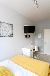 a bedroom with a bed and a desk and a tv at Ferienwohnung Raabstraße in Nuremberg