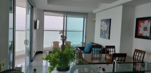 una sala de estar con mesa y sillas y el océano en Palmetto Eliptic Bahia, en Cartagena de Indias