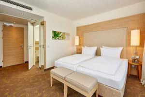 Postel nebo postele na pokoji v ubytování H+ Hotel Salzburg