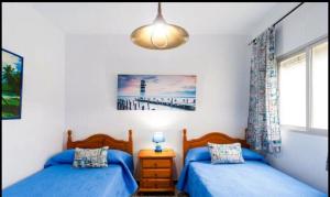 科尼爾－德拉弗龍特拉的住宿－Apartamento de las Flores en Conil，一间卧室配有两张床,光线充足