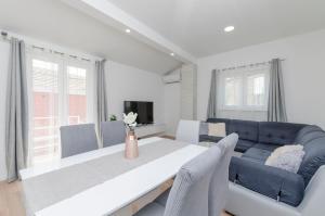 uma sala de estar com uma mesa e um sofá azul em Apartments Dasa em Primošten
