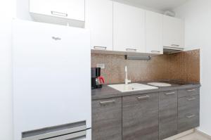 een keuken met witte kasten en een wastafel bij Apartments Danica in Primošten