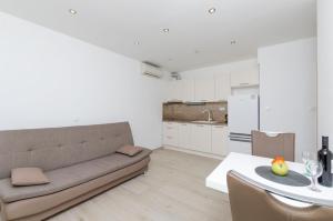 een woonkamer en een keuken met een bank en een tafel bij Apartments Danica in Primošten