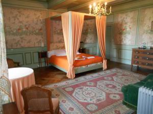 - une chambre avec un lit à baldaquin orange dans l'établissement Le Château d'Ailly, à Parigny