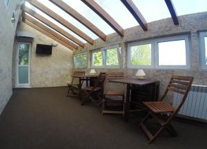 a room with wooden tables and chairs and windows at Guest House Miya Domodedovo in Domodedovo