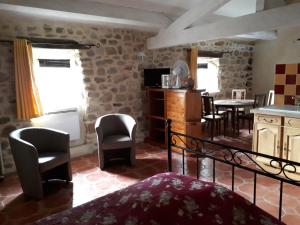 Les AssionsにあるGîtes Mas de la Musardièreのキッチン、テーブル、椅子が備わる客室です。