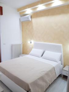 sypialnia z dużym białym łóżkiem z białymi poduszkami w obiekcie Dream & Relax w mieście Vieste