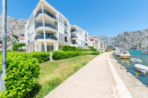 a building next to a river with boats in it at Apartment Ivanka in Omiš