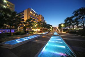 a row of water features in a street at night at Hotel Monica in Riccione