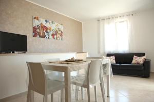 a living room with a table and chairs and a couch at Villetta Sofia in Marina di Pescoluse