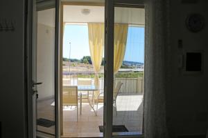 a glass door leading to a balcony with a table and chairs at Villetta Sofia in Marina di Pescoluse