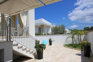 a balcony of a house with stairs and potted plants at Villetta Sofia in Marina di Pescoluse