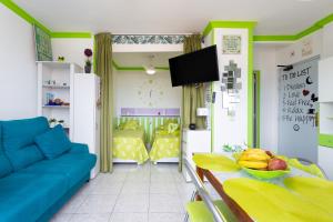 Apartamento vistas al mar Valle Luz في بويرتو دي لا كروث: غرفة معيشة مع أريكة زرقاء وطاولة