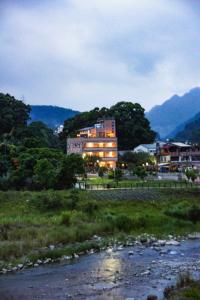 a building with lights on next to a river at Lisin Village Homestay in Nanzhuang